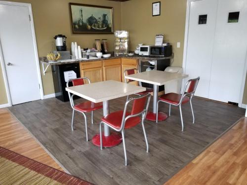 une cuisine avec deux tables et des chaises rouges dans l'établissement The Simplicity Inn, à Marshfield
