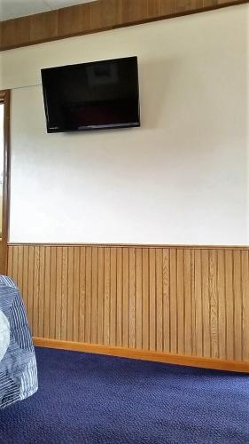 a room with a flat screen tv on a wall at The Simplicity Inn in Marshfield