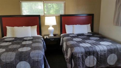 a hotel room with two beds and a lamp at The Simplicity Inn in Marshfield