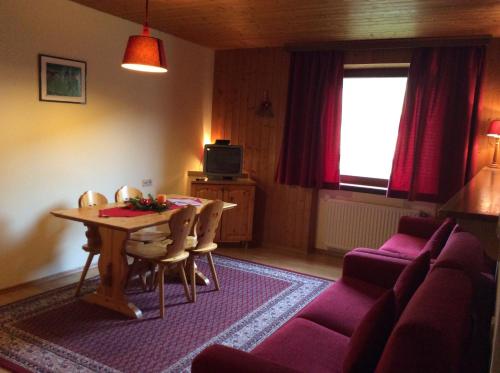 ein Wohnzimmer mit einem Tisch und einem Sofa in der Unterkunft Residenze Sonnenschein Casa Bianca in Niederdorf