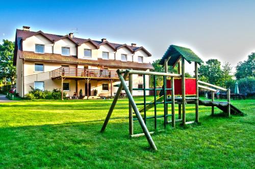 a playground in front of a large house at LAGO Apartamenty i pokoje in Łeba