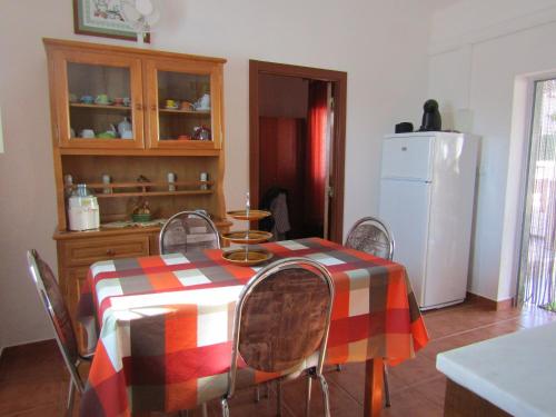 a kitchen with a table with chairs and a refrigerator at Casa da Horta in Aroeira