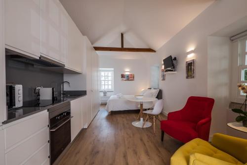 リスボンにあるSoul House - Exclusive Apartmentのキッチン、リビングルーム(赤い椅子、テーブル付)