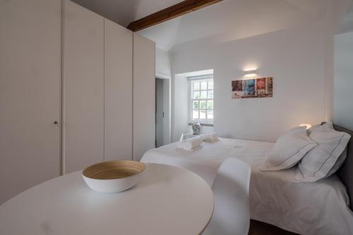 リスボンにあるSoul House - Exclusive Apartmentの白いベッドルーム(白いベッド1台、テーブル付)