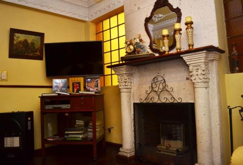 sala de estar con chimenea y TV en El Balcon Hostal Turistico, en Arequipa