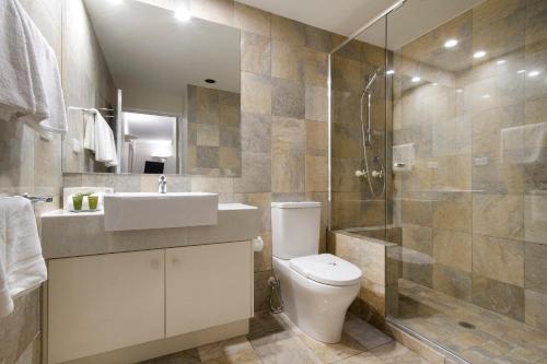 uma casa de banho com um WC, um lavatório e um chuveiro em Alderly Apartment 11, Little Cove em Noosa Heads