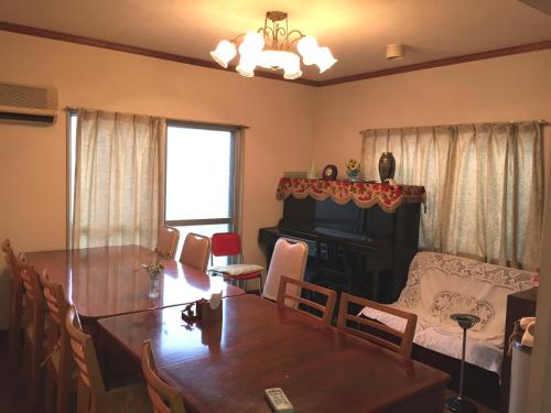 a living room with a dining room table and a living room at Aoi Business Hotel in Fukuyama