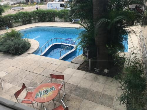 uma piscina com mesa e cadeiras ao lado em Palmar Hotel Casino em Concordia