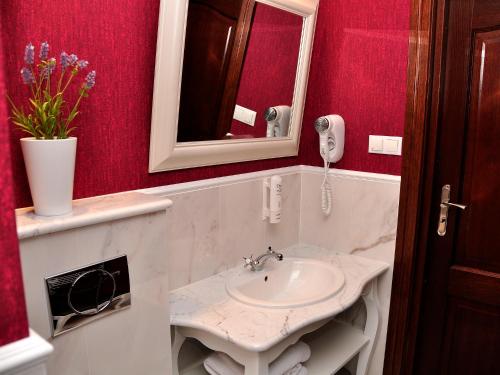 a bathroom with a sink and a phone at SleepWalker Boutique Suites in Wrocław