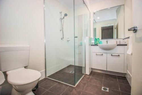 a bathroom with a shower and a toilet and a sink at The Happy Delightful Place - Entire 2 Room Apartment in Cockburn Central