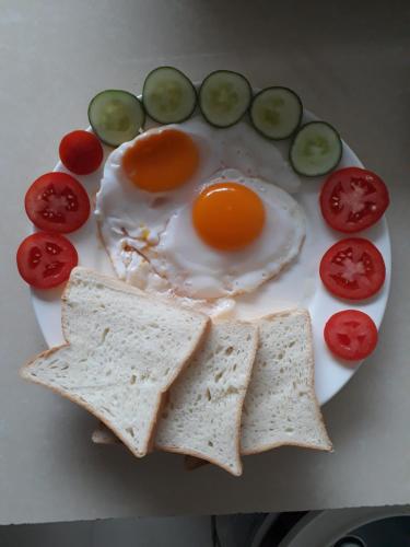 ニンビンにあるCenter Tam Coc Homestayのテーブルの上に卵とトマトの載った皿