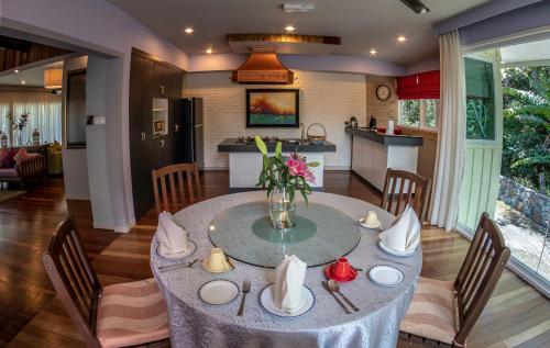 a dining room table with a vase of flowers on it at Sutera Sanctuary Lodges At Kinabalu Park in Kundasang