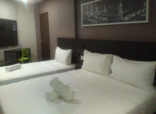 a hotel room with a bed with a hat on it at The Loft Plaza Hotel in Bangi
