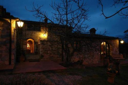a stone house with lights on it at night at Albergo Il Colombaio in Castellina in Chianti