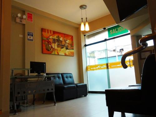 a waiting room with a couch and a sliding glass door at Hotel Primavera in Chiclayo