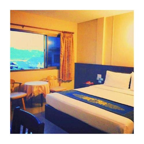 a hotel room with a bed and a window at Chiangkhong Green Inn Resident in Chiang Khong