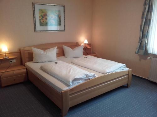 a bedroom with a bed with white sheets and pillows at Sonneneck in Winterberg