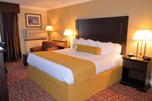 a hotel room with a large bed and a chair at Best Western Plus Wilkes Barre Center City in Wilkes-Barre