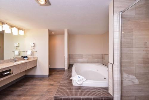 a bathroom with a tub and a sink and a shower at Best Western Kelly Inn - Yankton in Yankton