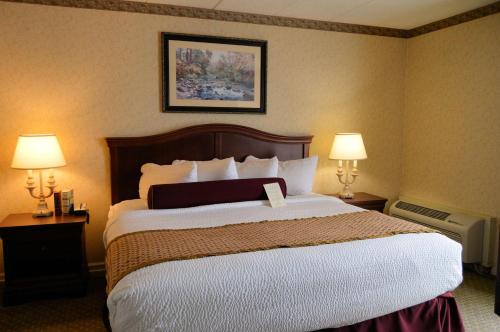 a hotel room with a large bed with two lamps at Best Western Plus Wilkes Barre Center City in Wilkes-Barre
