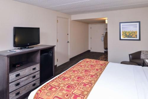 a hotel room with a bed and a flat screen tv at Best Western Kelly Inn - Yankton in Yankton