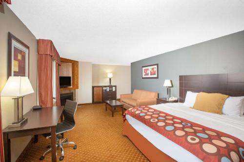 a hotel room with a large bed and a desk at AmericInn by Wyndham Coralville in Coralville