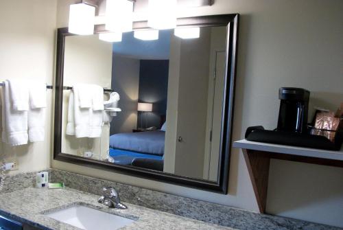 een badkamer met een wastafel en een grote spiegel bij AmericInn by Wyndham Beulah in Beulah