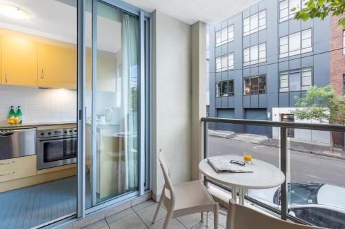 a kitchen with a balcony with a table and chairs at Nesuto Chippendale in Sydney