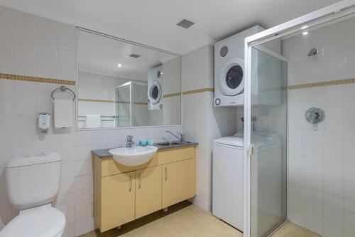 a bathroom with a toilet and a sink and a shower at Nesuto Chippendale in Sydney