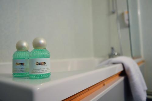 two bottles of water sitting on top of a bathroom counter at Hôtel de France in Saint-Savin-sur-Gartempe