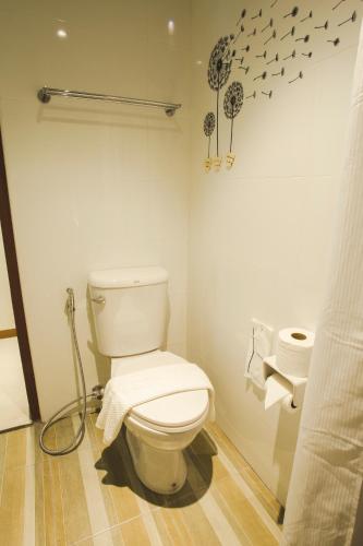 a bathroom with a toilet with a shower curtain at Chada Mantra Hotel in Chiang Mai