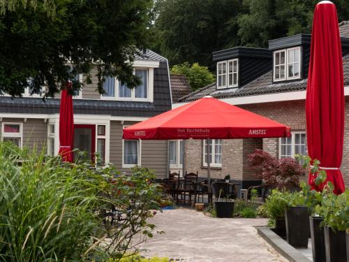 a red umbrella in front of a house at Hotel-Restaurant Het Rechthuis in Muiderberg