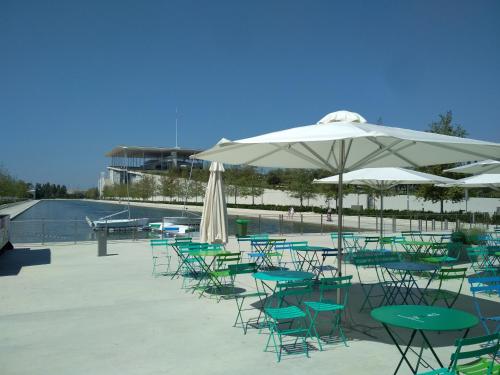 a group of tables and chairs with an umbrella at George's Apartment in Athens