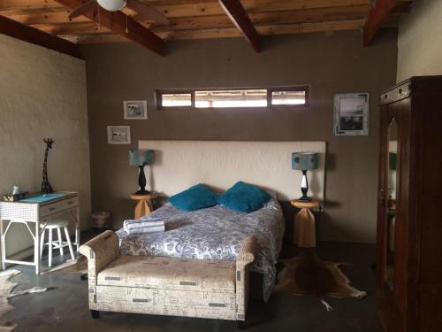 a bedroom with a bed and a table and a window at Olievenhoutsrus Guest- and Game Farm in Vaalwater