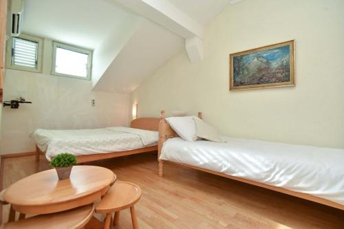 a room with two beds and a table in it at Comfort Inn Old Town in Budva