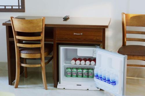 a desk with a refrigerator with bottles of water at Dream Flower Homestay in Hoi An