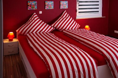 two red and white striped beds in a bedroom at URS Ferienwohnung Wertheim in Wertheim