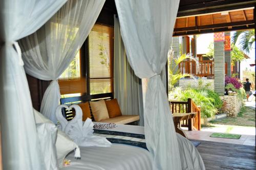 a bedroom with a bed with white curtains at Ocean Terrace Suite And Spa Luxury in Nusa Penida
