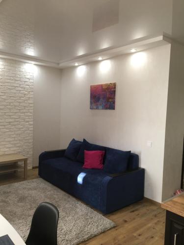 a living room with a blue couch with a red pillow at Апартаменты в 3км аэропорта Киев in Vyshneve