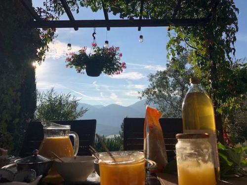 a table with glasses of orange juice and a bottle at Chambre d'hôtes La Citadelle in Lardier-et-Valença