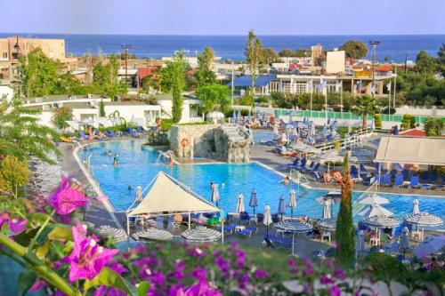 a large swimming pool with people in a resort at Sun Palace Hotel in Faliraki