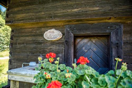 a wooden building with red flowers in front of it at Hütte zum Verlieben in Gurk
