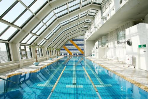 a large indoor swimming pool with blue water at Swissotel Nankai Osaka in Osaka