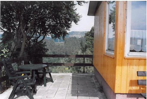 a patio with a table and chairs and a tree at Ferienhaus "Eierkuchen" in Lindig