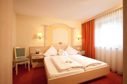 レンゲンフェルトにあるFerienresidenz La Vitaのベッドルーム1室(ベッド1台、椅子、窓付)
