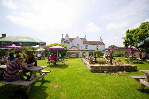 a group of people sitting at picnic tables in a garden at The Globe Inn Alvington in Alvington
