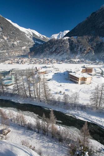 a snow covered valley with a building and a river at Ferienresidenz La Vita in Längenfeld