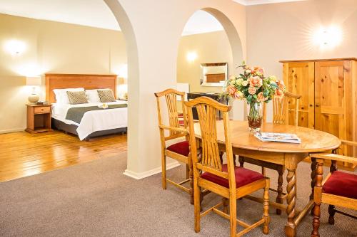 a room with a table and a bedroom with a bed at Nolangeni Hotel in Kokstad