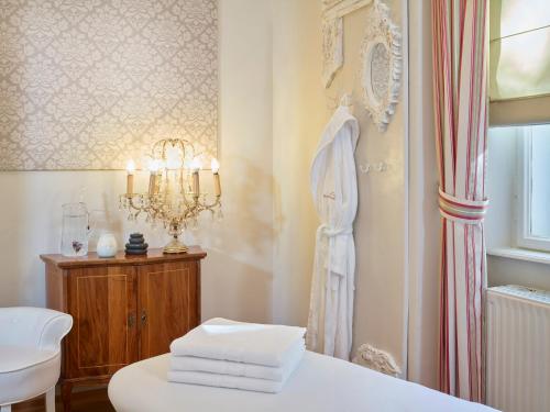 a bathroom with a white bed and a chandelier at Hapimag Ferienwohnungen Bad Gastein in Bad Gastein
