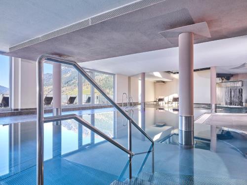 a swimming pool with a glass floor and stairs at Hapimag Ferienwohnungen Bad Gastein in Bad Gastein